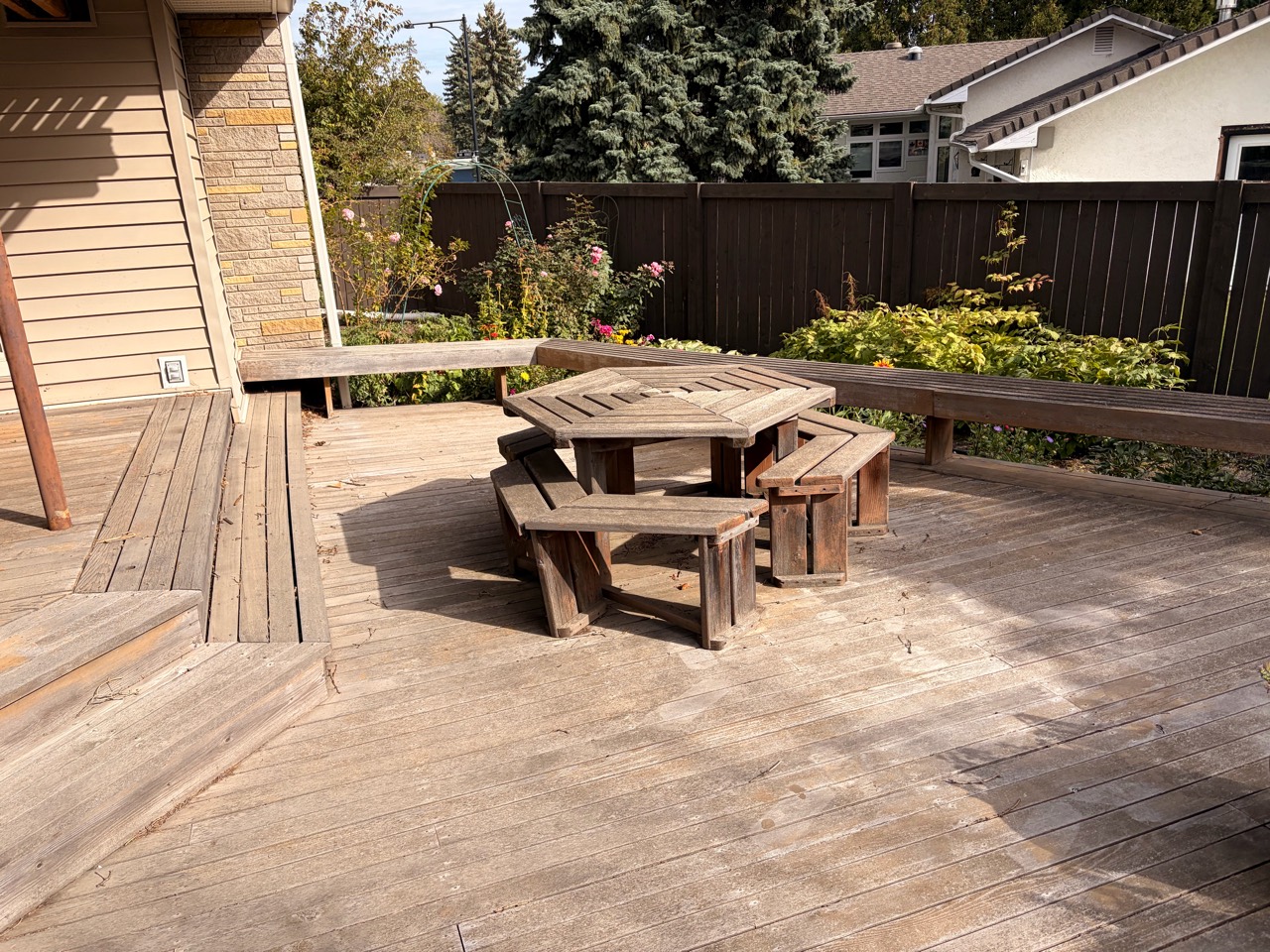 Before pickup: an old wooden patio table and freestanding seats on the deck